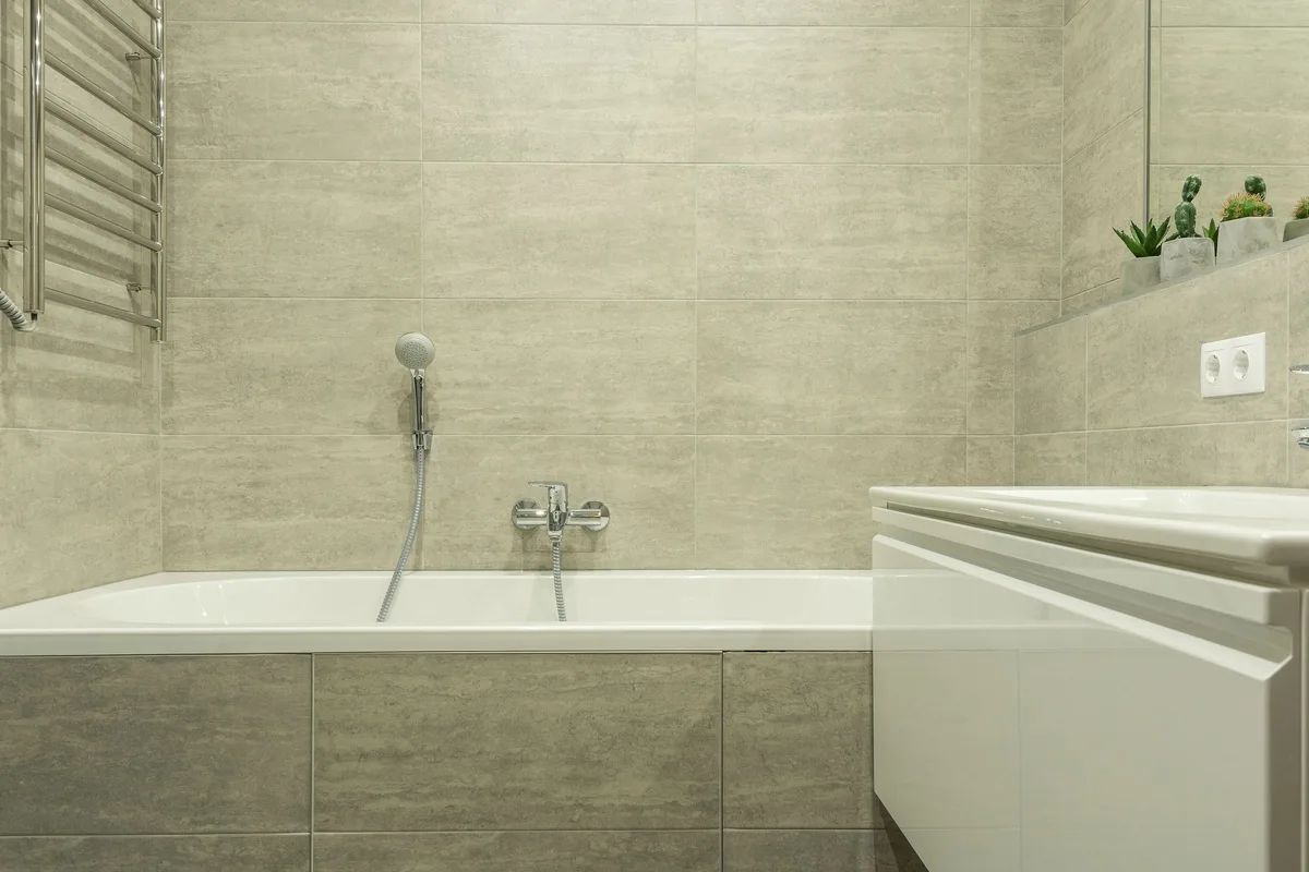 Clean, dry bathroom with a tiled tub surround