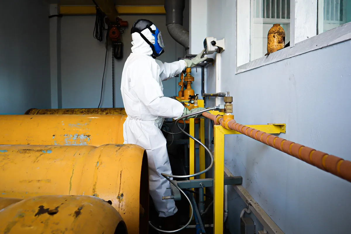 Remediation technician in a protective suit and respirator